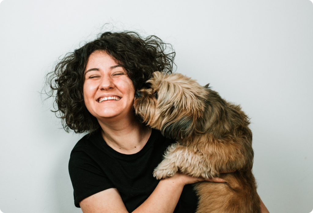 Smiling woman holding a dog in her hands